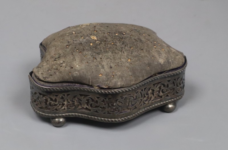An Edwardian silver mounted shaped pin cushion, on bun feet, Birmingham, 1904, width 18cm.